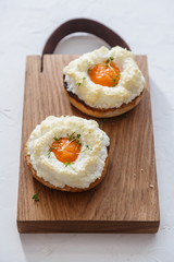Eggs orsini with greens on wooden background