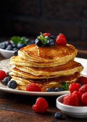 Homemade american pancakes with fresh blueberry, raspberries and honey. Healthy morning breakfast. rustic style