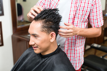 Close-up of male barber grooming the client's hair