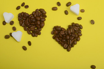 Coffee beans in heart shape on yellow background