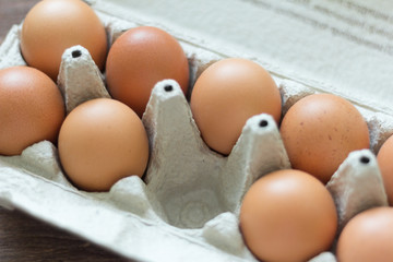 chicken eggs in a cardboard box, with one empty cell