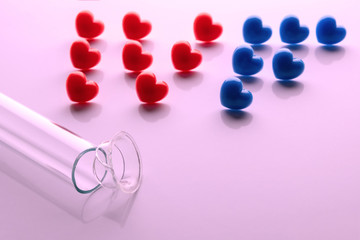 Abriveura IVF from red hearts and a broken test tube in the foreground on a pink background. Concept of unsuccessful in vitro fertilization. The theme of the shattered dream of a newborn. Copy space.