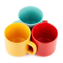 Colored cups for coffee and tea on a white background. Place for your text.