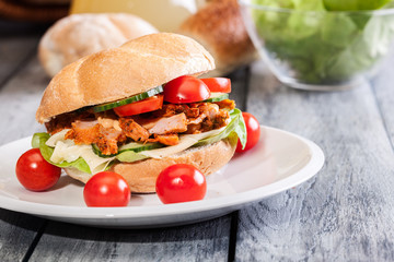 Fried chicken meat with cheese and vegetables in bun