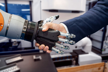 Hand of a businessman shaking hands with a Android robot.