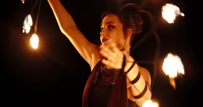 Cool female fire show artist is having a performance, flailing her equipment in darkness - slow motion 4k