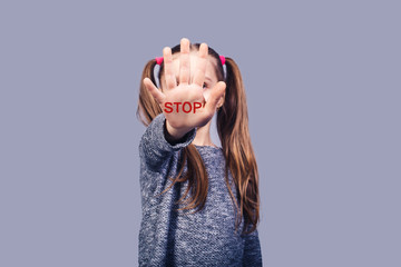 sad little girl shows hand stop sign. Concept stop child abuse.