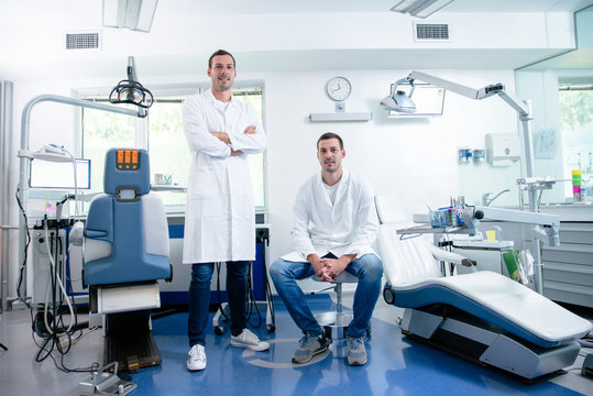 Two professional confident dentists near dental chair.