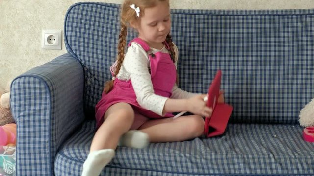 Little girl coloring on a tablet