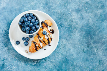 Croissant with chocolate and fresh blueberries.