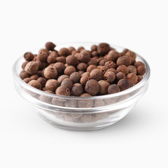 Allspice in glass bowl on white.