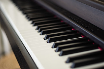 Fototapeta na wymiar Close up view of electric piano black and white Keys with blurred background 