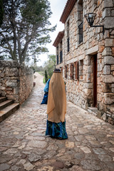 Obraz na płótnie Canvas Mujer con vestido árabe caminando por una calle de la aldea medieval de Ciurana o Siurana 
