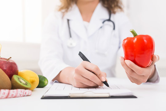 Female nutritionist counting calories in hospital, closeup