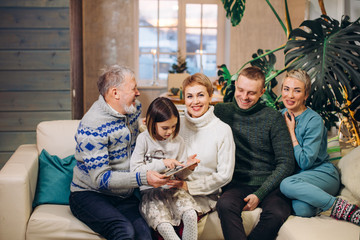 little girl is holding photo album in her hands while her relatives are smiling. close up shot.