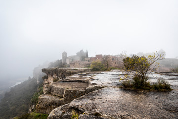 Aldea medieval de Ciurana o Siurana en la niebla sobre el riscal de la Sierra de la Gritella