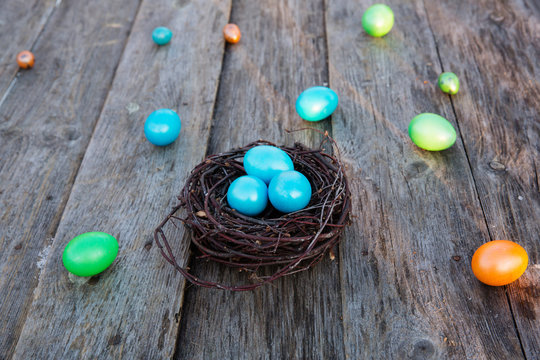 Colorful Easter egg in the nest on wooden background