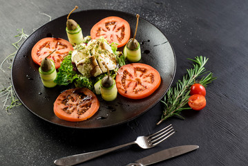A dish from goat cheese and vegetables on black