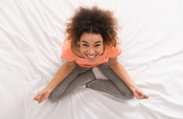 African-american woman meditating on the bed, top view