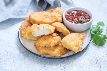 Fried crispy chicken breast nuggets with sauce