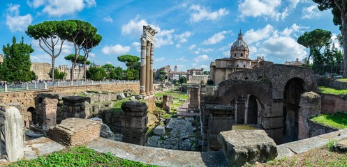 Fototapeta na wymiar Panoramic View of the temple of Saturn in Roman forum, Italy. Ruins of Septimius Severus Arch and Saturn Temple. 