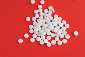 Tablets medicine for people's health to heal diseases, top view of the Spilled white pills on the white surface.