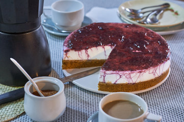Homemade cheese cake with cranberry jam, served with a coffee