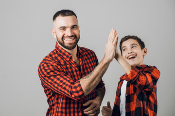 Handsome man giving high five to his son on white background. close up photo, friendship, happiness, game, yea, we've done it.