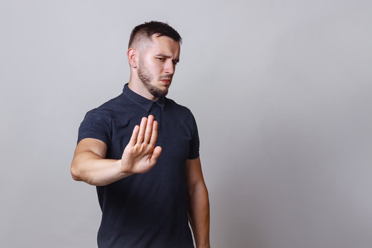 Nope not today or stop right there. Handsome young man wearing blak shirt doing stop sing with palm of the hand. Warning expression with negative and serious gesture on the face.