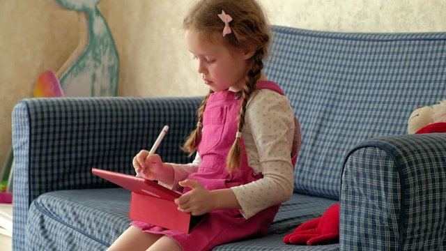 Little girl coloring on a tablet