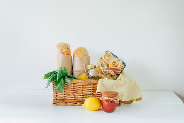 Obraz na płótnie Canvas Italian food basket with bread, basil, olive oil, lemons, and a bottle of wine.