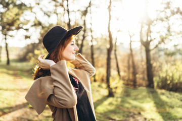 Pretty and happy red hair girl walking in the forest