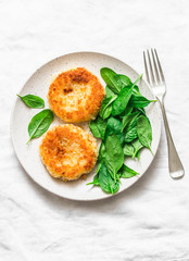 Potato bread crumbs baked cakes with spinach on a light background, top view. Delicious vegetarian lunch