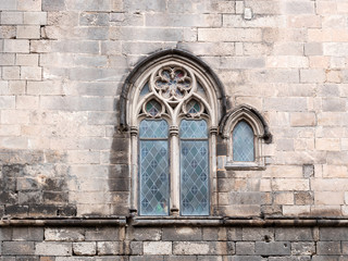Traditional ancient gothic style window. Old vintage window on stone wall.