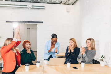 diversity, race, height, success and people concept - multi-ethnic group of happy women clapping...