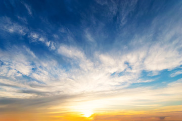 Sky blue and orange light of the sun through the clouds in the sky