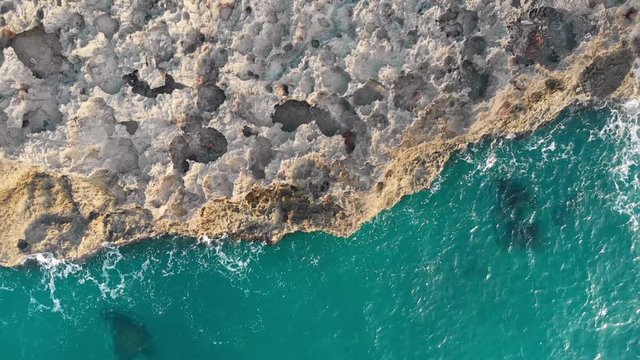 View from the top as ocean waves break on the rif