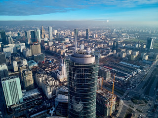 WARSAW, POLAND - NOVEMBER 27, 2018: Beautiful panoramic aerial drone view to the center of Warsaw City and The Warsaw Spire - 220 metre neomodern office building on European square (Plac Europejski) - obrazy, fototapety, plakaty