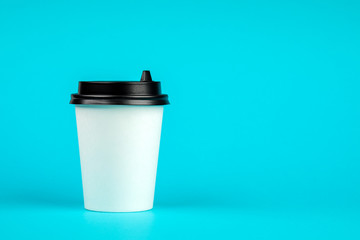 Paper coffee container with black lid on blue background. Take-away beverage container. Drink Cup template for your design.