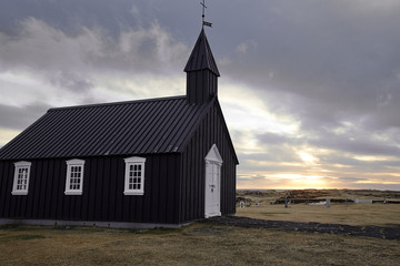 Fototapeta na wymiar Famous picturesque black church of Budir at Snaefellsnes peninsula region in Iceland during strong wind and dramatic sky