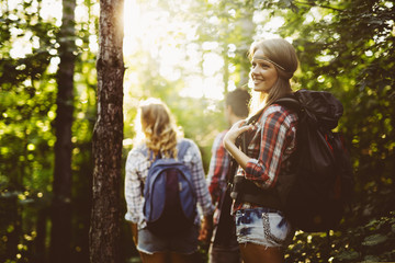 Beautiful woman and friends hiking in forest
