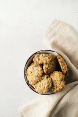 Homemade oat cookies in bowl on white background