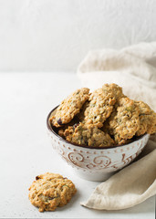 Homemade oat cookies in bowl on white background