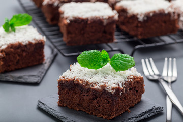 Homemade brownie with coconut flakes, swedish dessert Karleksmums, cut in square servings, on a...