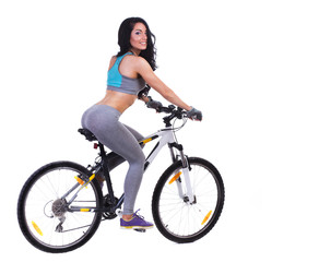 Fototapeta na wymiar Woman on a bicycle dressed in a sports uniform in gray in the studio on a white background