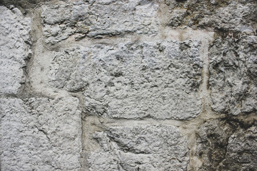 Dirty gray closeup background of old urban brick wall. Empty grey concrete brickwall with dark damaged corner