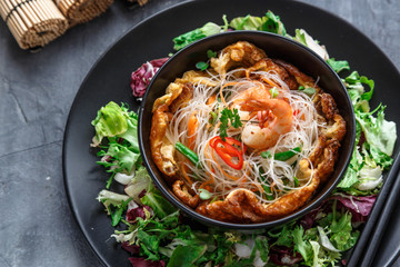 Asian salad with rice noodles with shrimps and vegetables closeup.