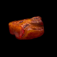 Natural piece of natural amber on black background