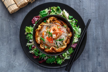 Asian salad with rice noodles with shrimps and vegetables closeup.