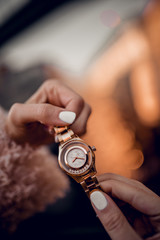 Stylish golden watch in woman hands